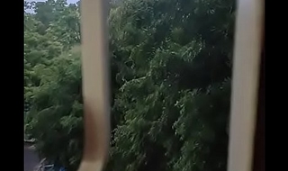 Husband fucking wife in bullwhips style by enjoying the rain from window